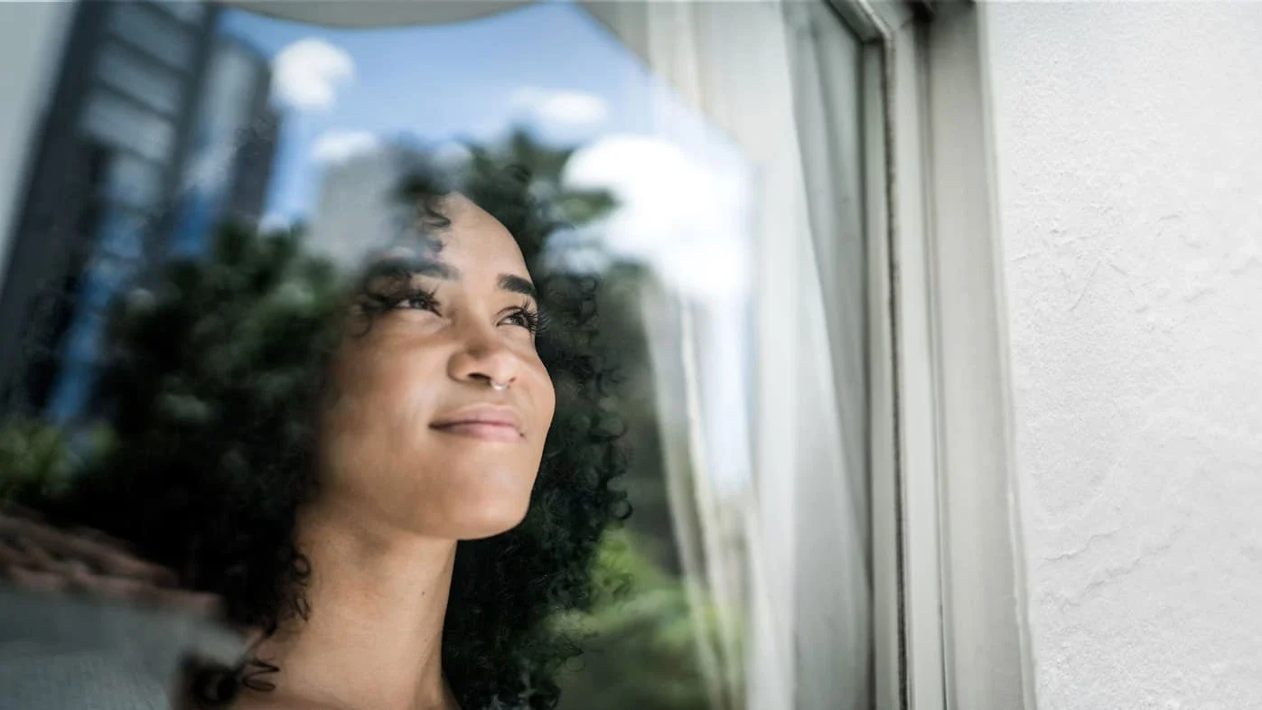 African American woman looking out a window